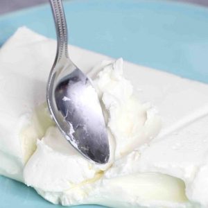 Checking whether cream cheese is softened using the back of a spoon