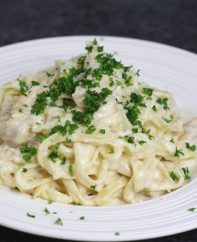 Homemade chicken alfredo garnished with fresh parsley