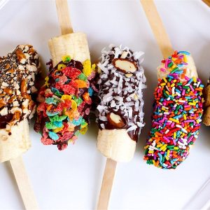 Chocolate Covered Bananas are the easiest snacks ever! Just 3 ingredients: banana, chocolate and coconut oil, plus whatever toppings you like such as crushed M&Ms, fruity pebble cereal, cinnamon toast crunch and colored sprinkles. Beautiful and irresistibly delicious! Quick and easy recipe. Kids friendly. Video recipe. | Tipbuzz.com #ChocolateCoveredBananas #ChocolateBananas