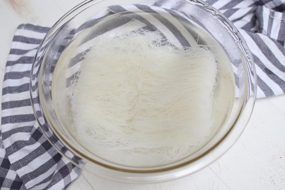 Soaking mei fun noodles in water to soften before stir frying