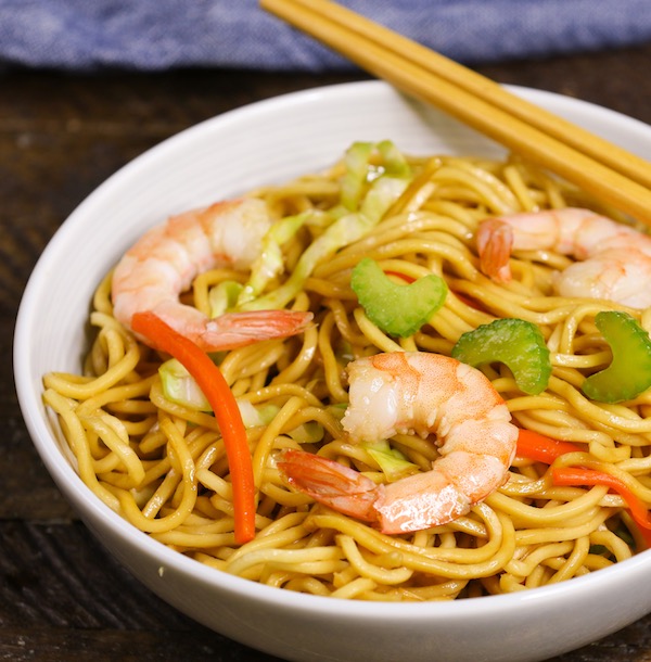 Shrimp Lo Mein with celery, red bell peppers and green onions in a serving bowl with chopsticks