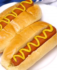 Perfectly boiled hot dogs in buns and dressed with mustard