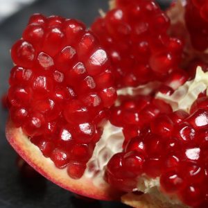 Closeup of a pomegranate that has been cut open to expose the juicy red arils inside