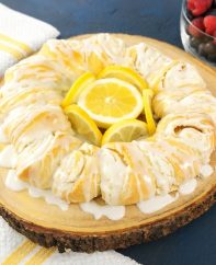 Quick And Easy Lemon Cheesecake Crescent Ring (video recipe) - bursting with irresistible lemon flavour! Tender and flaky crescent ring filled with creamy lemon cheesecake and topped with lemon zest! All you need is a 7 simple ingredients: cream cheese, lemon juice, lemon zest, sugar, crescent roll dough and milk. Perfect for Easter or any holiday breakfast or brunch! Vegetarian. | tipbuzz.com