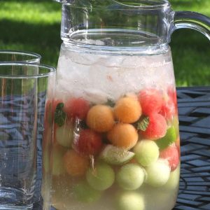 A pitcher of watermelon mojito with highball glasses - the perfect summer cocktail!