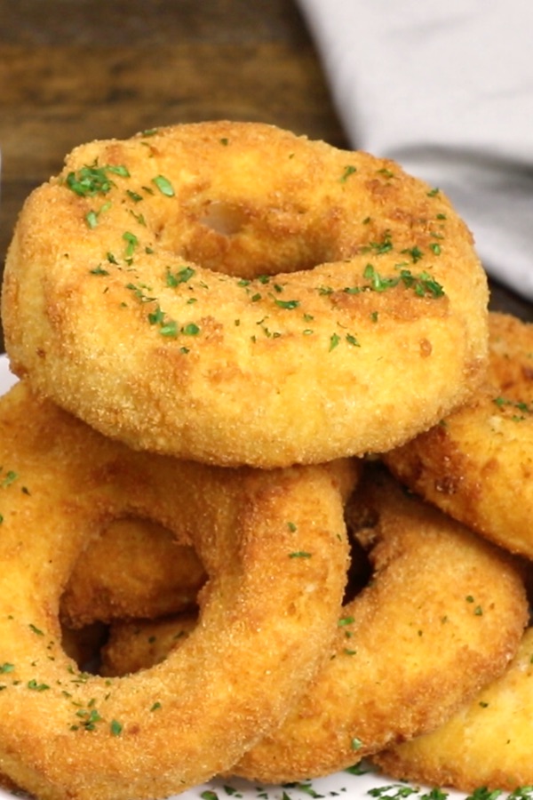 A stack of mac and cheese onion rings on a serving plate