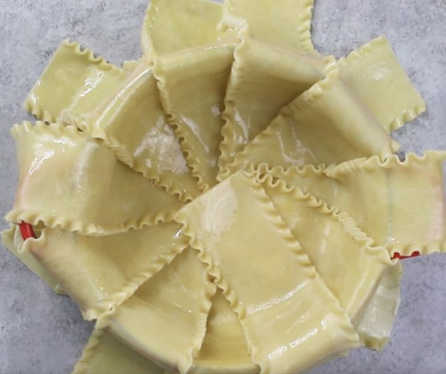 This photo shows how to layer cooked lasagna noodles into an ovenproof pot to make Party Lasagna