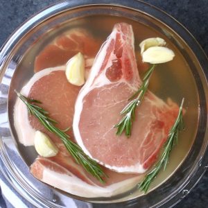 This easy pork chop brine recipe is made with salt, brown sugar, apple cider vinegar, rosemary, garlic, and water. It guarantees tender and juicy meat every time! The brined pork chops are perfect for grilling, pan frying, or baking.