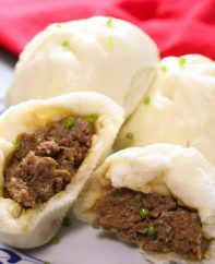 Chinese steamed pork buns served on a plate as part of a dim sum style lunch