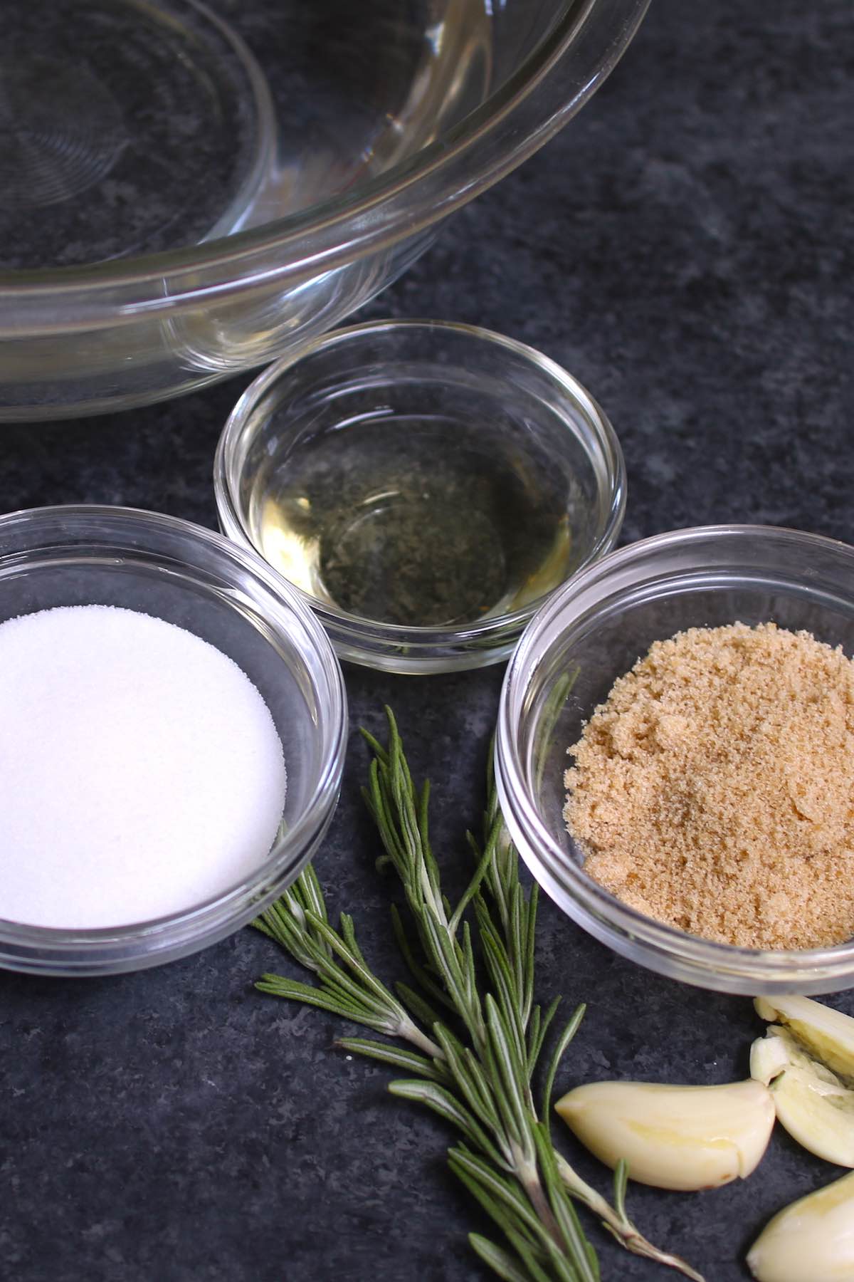 Bowls of brown sugar, salt and cider vinegar with fresh rosemary
