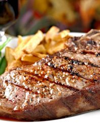 Bone-in grilled strip steak served with fries