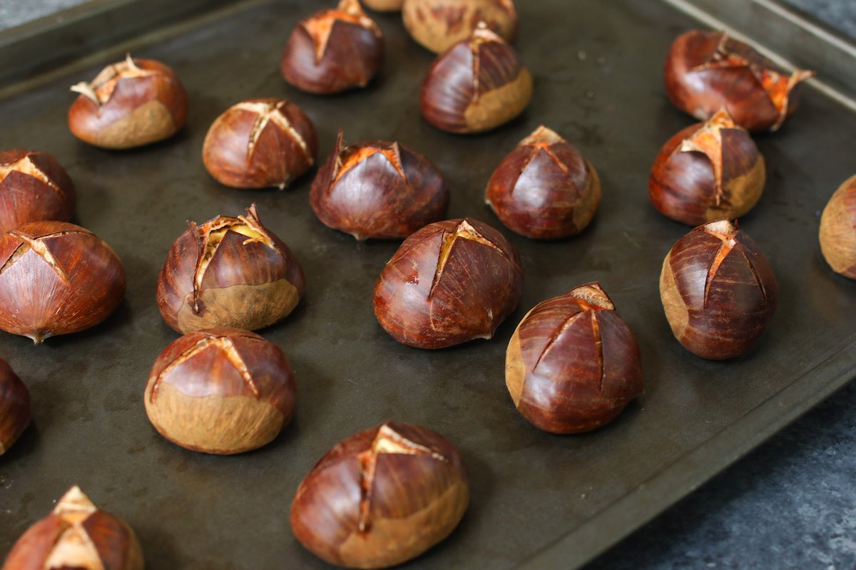 Adding soaked chestnuts to the sheet pan with flat side facing down.