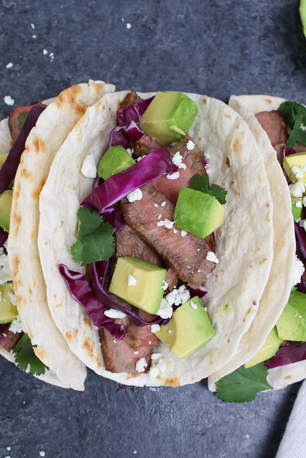 Homemade steak tacos made with sirloin steak, hot flour tortillas, toppings and queso fresco cheese for a delicious lunch or dinner idea