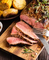 Slices of top round roast beef on a carving board