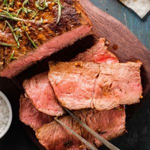 Top round roast of beef on a carving board