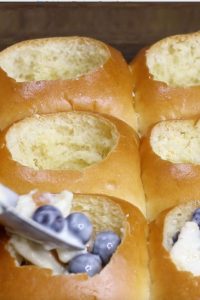 Spooning the blueberry mixture into the dinner rolls