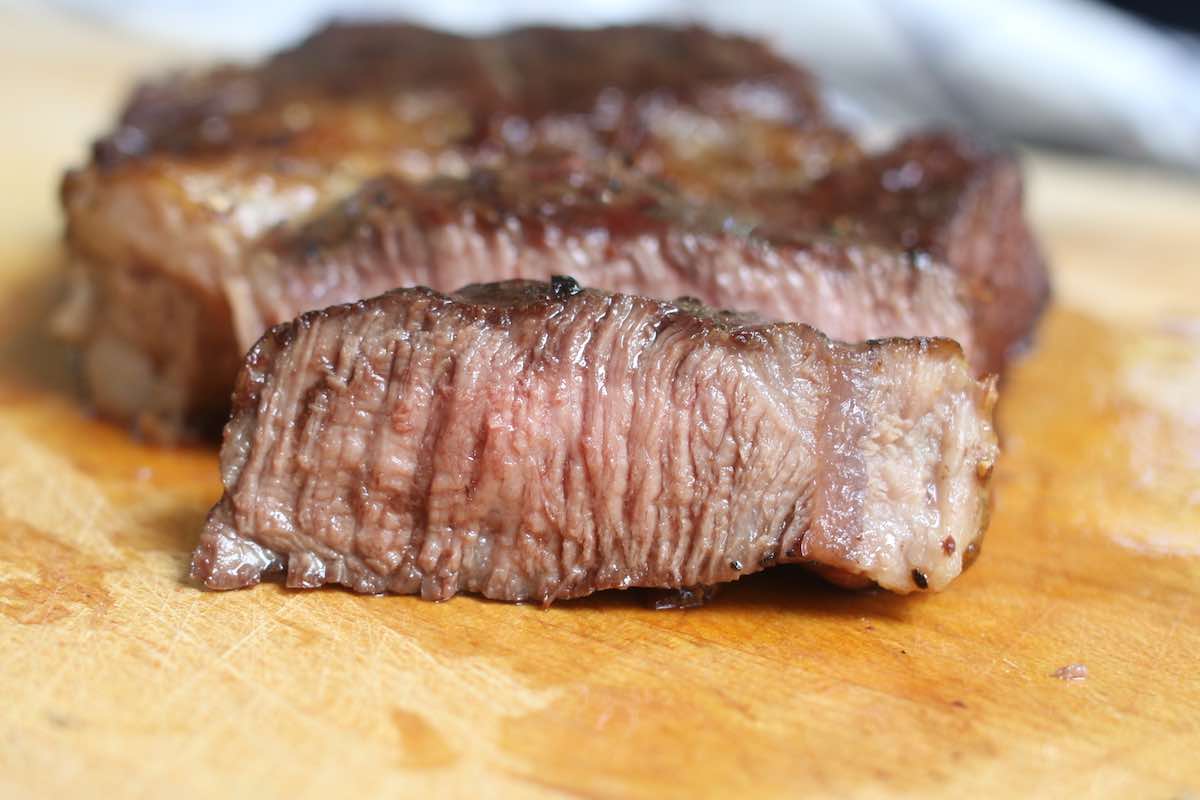 Closeup of steak grilled well-done with no pink color left on the inside of the meat